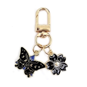 Detail of alloy butterfly and cherry blossom charms on a gold keychain