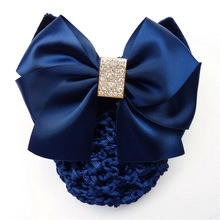 Close-up of a navy blue satin bow hairnet with shimmering rhinestone buckle detail