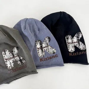 Slouchy beanie with large K letter print and rivet detail in grey and black knit fabric