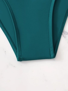 Close-up of peacock green ribbed fabric and flatlock stitching for women swimwear
