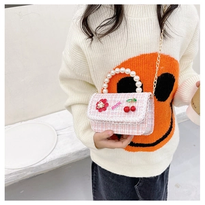 Close-up of pink tweed crossbody bag for girls with pearl handle and metal chain strap