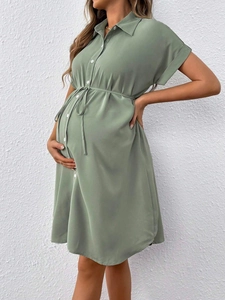 Side view of light green maternity shirt dress with buttons and waist drawstring