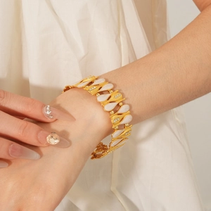 Close-up of vintage golden bracelet with white water-drop zircon charms on woman wrist