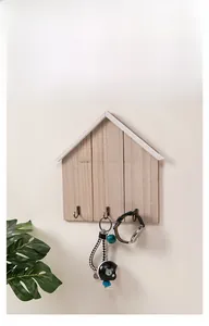 Detail of wooden house-shaped wall hook with HOME text and three metal hooks