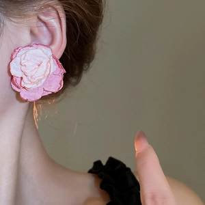 Detailed view of large handmade woven lace flower clip-on earrings in pink gradient