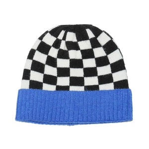 Detail of checkered knit beanie with royal blue ribbed cuff showing premium texture