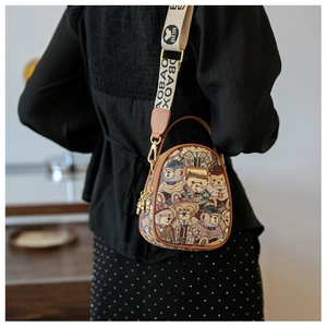 Detail view of jacquard dome crossbody bag with bear print and wide woven strap on model