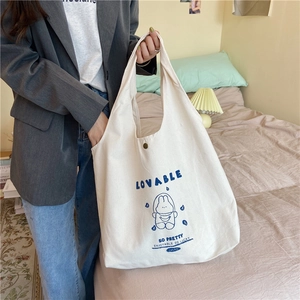 Détail d'un sac en toile avec illustration de lapin et lettrage bleu sur un tissu de qualité