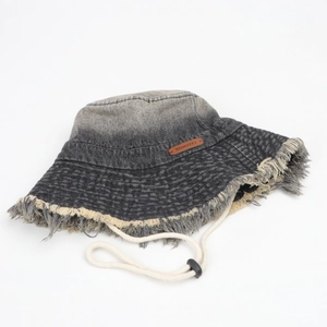 Detail view of denim sun hat with frayed edges, gradient wash, and adjustable wind cord