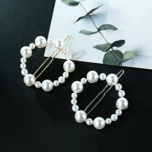 Elegant gold and silver hair clips with round faux pearls on a minimalist background