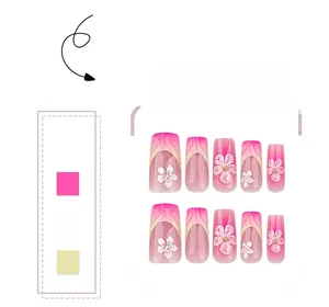 Detail of pink gradient press-on nails with hand-painted white flowers and gold beads