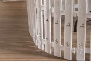 Close-up of white plastic Christmas fence with hollow snowflake and reindeer patterns