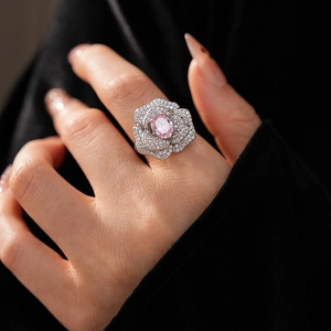 Close-up of a floral zircon ring with oval pink stone on model hand