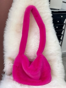 Close-up of hot pink faux fur shoulder bag with soft plush texture and fluffy strap