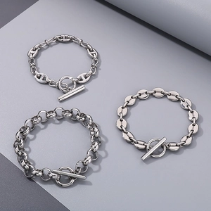 Trois bracelets à maillons en acier inoxydable argenté avec fermoir OT en T sur gris