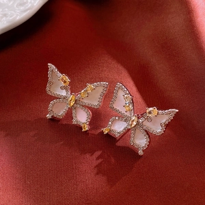Detailed view of silver butterfly stud earrings with mother-of-pearl and cubic zirconia