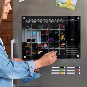 Macro detail of magnetic acrylic weekly planner with six colorful markers on a fridge
