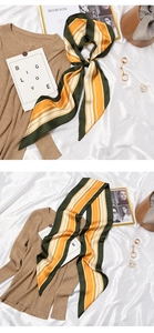 Flat lay of green and yellow striped silk scarf with a bag and decorative items