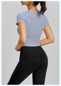 Dettaglio del top a maniche corte azzurro e dei leggings neri a vita alta da yoga