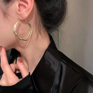 Eleganti orecchini a cerchio geometrici quadrati dorati indossati da una modella