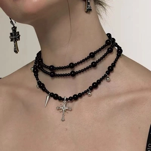 Detail of Y2K gothic multilayer necklace with black beads and silver cross pendants
