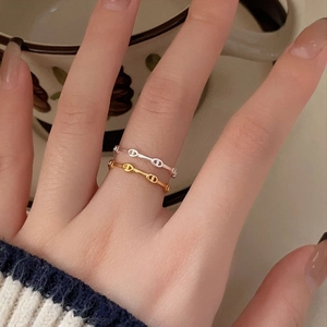 Detail of minimalist 925 silver link chain rings in gold and silver finish on hand