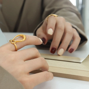 Minimalist geometric twisted gold ring with micro-pave zircons shown in a mirror reflection
