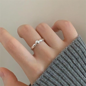 Close-up of minimalist 925 silver beaded open ring on model finger with cozy knit sweater