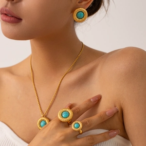 Model wearing vintage style turquoise stone necklace and hammer-textured gold earrings set