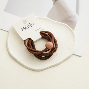 Detail of 4-piece elastic hair ties in brown tones with textured weave and matte bead