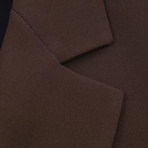 Close-up of the lapel detail showing high-quality brown twill fabric on a women's blazer