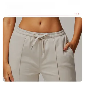 Detail of high-waisted jogging pants featuring an elastic waistband and adjustable drawstrings
