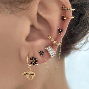 Close-up of gold ear cuff set with black zircon stones and delicate chains on ear