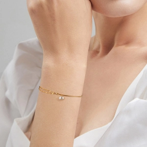 Elegant 925 sterling silver gold-plated bracelet with freshwater pearl on a model's wrist