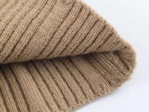 Detailed close-up of khaki chunky knit fabric texture showing thick yarn patterns