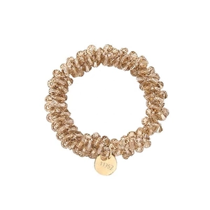 Elegant champagne crystal beaded hair tie with gold circular charm on white background