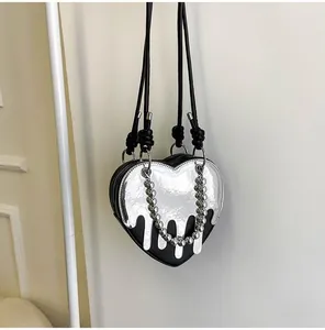 Detail of heart-shaped crossbody bag featuring silver fluid drip effect and bead chain