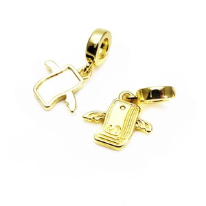 Detailed view of winged gold charms with zircon inlay and smooth polished back surface