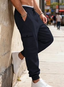 Side view of navy blue heavy fleece cargo jogger pants with large utility pockets on male model