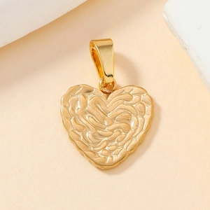 Macro shot of a golden heart pendant with a unique wavy texture on a minimalist base