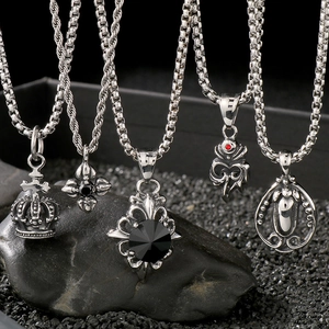 Macro shot of silver stainless steel pendant necklaces with gothic crown and cross motifs