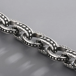 Macro detail of vintage silver stainless steel chain bracelet with hammered texture and beads