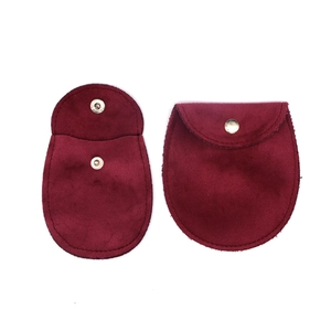 Close-up of burgundy velvet jewelry pouches showing open snap and closed exterior