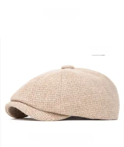 Detail of beige knit newsboy hat with retro textured wool blend fabric and short brim