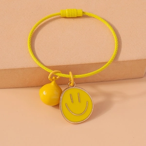 Close-up of yellow twisted wire keychain with creative smiley face and bell pendants