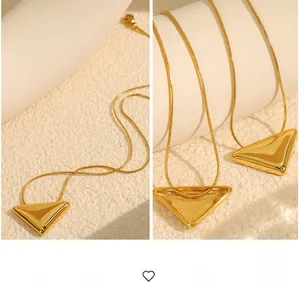 Detailed view of 18k gold plated snake chain with solid and hollow triangle pendants