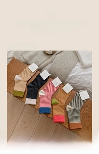 Détail de cinq paires de chaussettes en maille rayées avec étiquettes sur un banc