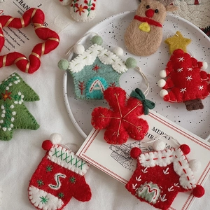 Flat lay of handmade wool felt Christmas ornaments including stars, gloves and mini trees