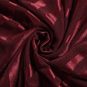 Gros plan sur le tissu en maille floquée rouge foncé avec texture à rayures satin