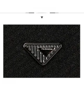 Close-up of fashion metal triangle logo on black wool texture of the winter baseball cap